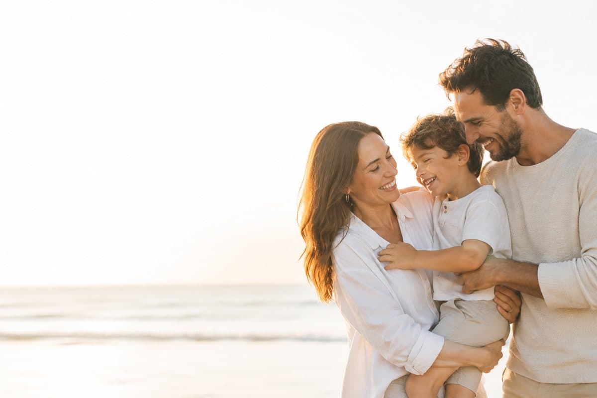 Una familia abraza a su hijo riendo al aire libre